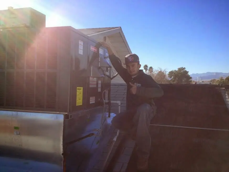 HVAC technician performing AC Tune-Up on a rooftop unit in Carlstadt