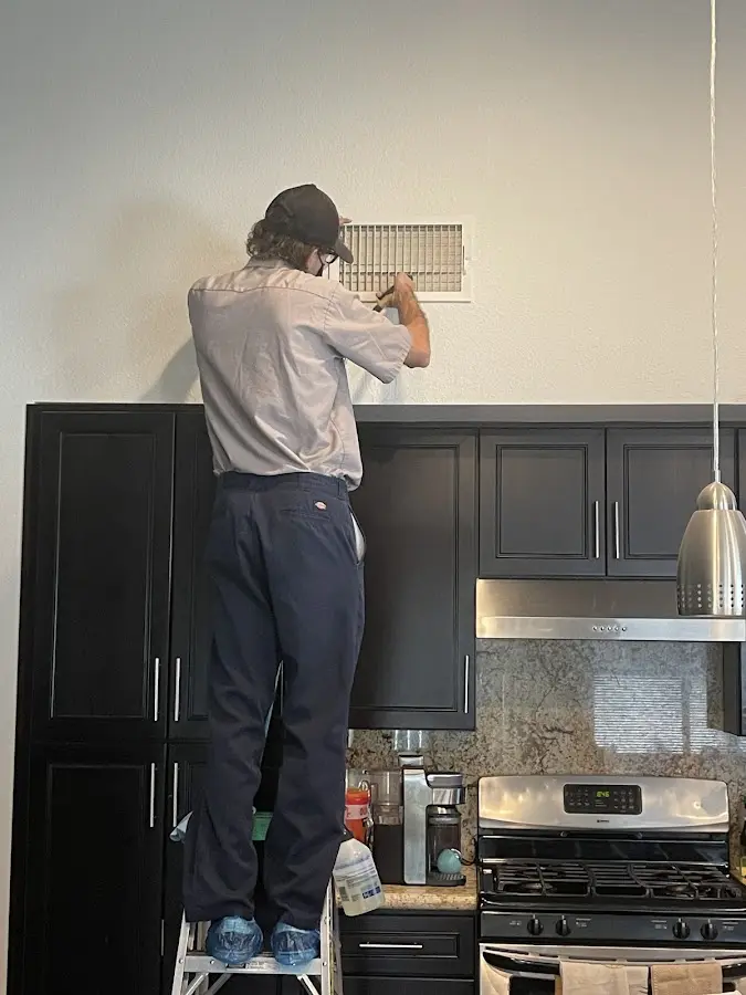 Technician inspecting an air vent during HVAC service in Carlstadt
